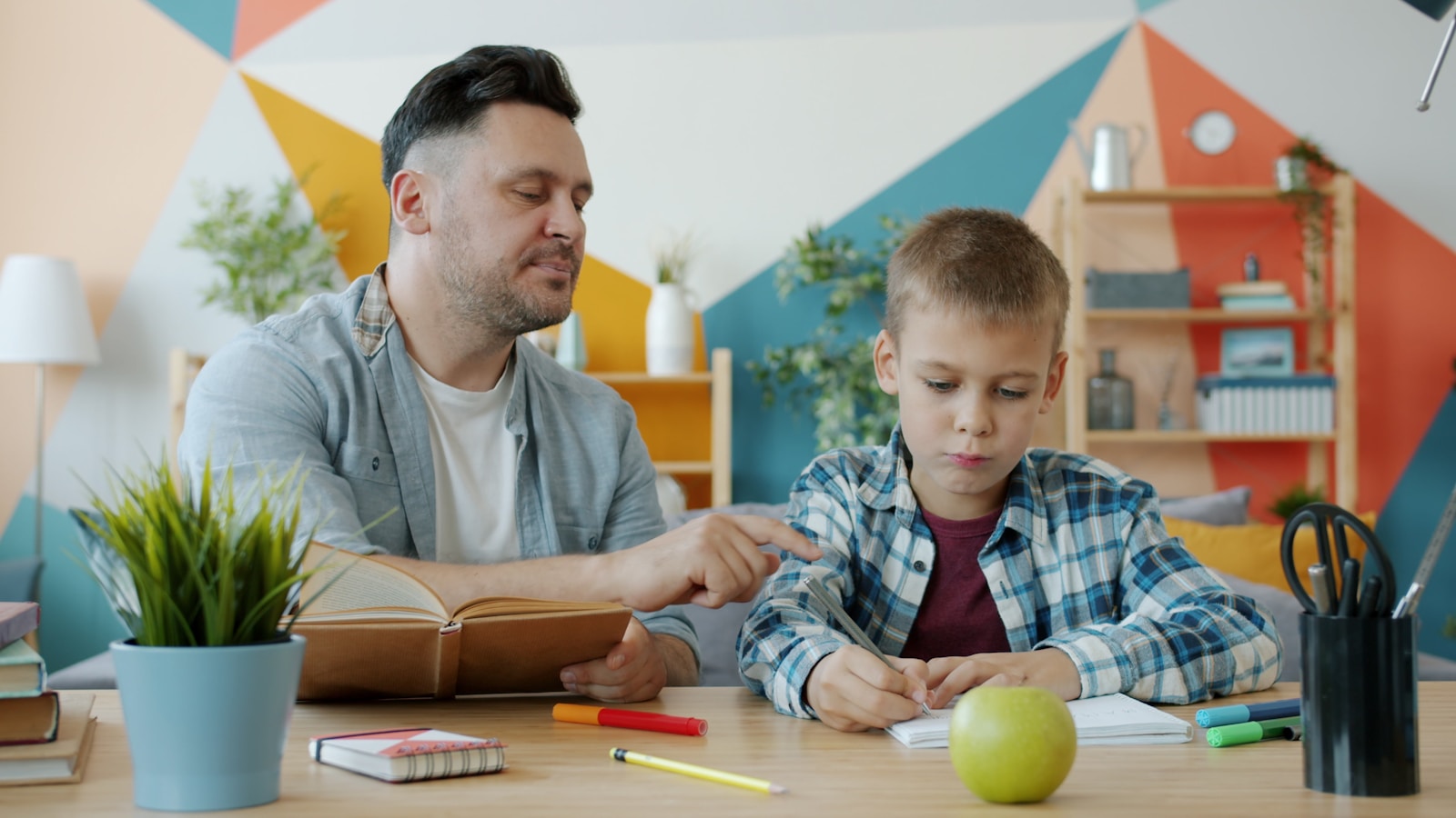 Adult and child working together at a table at home